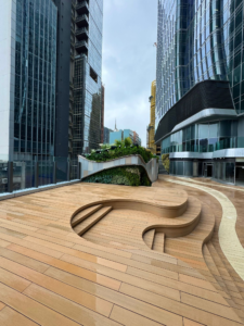 Close-up of wet sand-toned composite decking boards on a rooftop terrace, reflecting the light