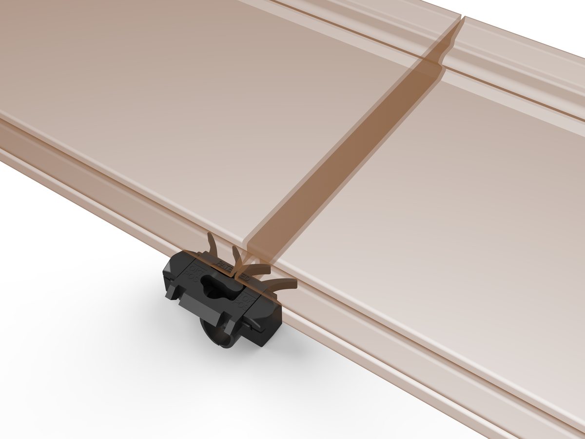 Shark clip gripping the side groove of a deck board from underneath